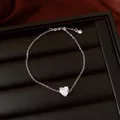 Détail macro d'un bracelet fin en argent avec un zircon en forme de cœur sur un présentoir. - Bracelet / Argent