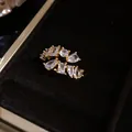 Close-up of gold open ring with various shapes of clear cubic zirconia. - Eco-friendly / Gold
