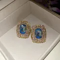 Dettaglio di orecchini a perno vintage ovali con cristallo blu oceano e strass - Stile Ovale Intarsiato con Strass / Oro-Blu