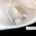 Close-up of retro silver wide cuff bracelet with detailed floral engraving and glossy finish - Vintage Floral Carving / Eco-friendly Silver