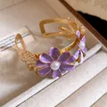 Detail shot of purple enamel flower bracelet with pearl center in gold finish - Purple
