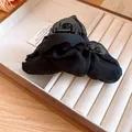 Detailansicht einer eleganten schwarzen Haarklammer aus Mesh-Stoff in einer Schmuckschale. - Haarklammer / Schwarz (Normale Qualität)
