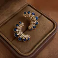 Elegant vintage flower stud earrings with deep blue gems and diamonds in jewelry box - Fan-Shaped Petal Style / Gold-Blue