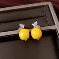 Close-up detail of luxury yellow lemon shaped earrings with sparkling zircon encrusted leaves - Silver Needle Studs / Silver/Yellow