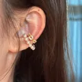 Close-up of elegant C-shape ear cuff with pearls and cubic zirconia on model ear - Single Piece / Gold