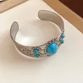 Vintage silver-tone cuff bracelet featuring oval turquoise stones and intricate floral carvings - Cuff Bracelet / Silver