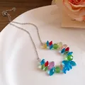Primo piano di perline di cristallo colorate su una catena in acciaio inossidabile su piatto. - Collana / Colorato