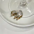 Detailed macro view of a gold-plated multi-layer ear cuff featuring sparkling pavé zircons - Gold