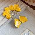 Macro view of vintage yellow enamel flower drop earrings showing fine texture and design - Yellow