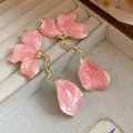 Detail shot of vintage pink enamel flower drop earrings with golden hardware finish - Pink