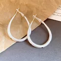 Detailed view of matte silver teardrop hoop earrings with black polka dots - Oval Polka Dot Earrings (HE33967)
