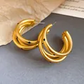 Detail of matte golden C-shaped hoop earrings featuring stylish black polka dot pattern - Triple Layer Gold Polka Dot Earrings