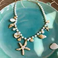 Close-up detail of a pearl necklace featuring golden starfish and natural shell charms. - Marine Element Pearl Necklace (5#)