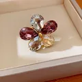 Close-up of a floral open ring with five pear-cut purple and clear crystals - Rhinestone Flower Open Ring (HR3603) / Gold-Multicolor