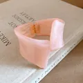 Close-up view of a pink marbled resin bracelet with a twisted geometric design and hinge - Bangle / Pink