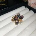 Detailed view of an elegant floral open ring with grey and amber crystals on white - Gold-Multicolor