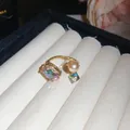 Detail view of ornate open ring with iridescent crystals and champagne pearl - Gold-Pink
