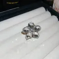 Macro view of elegant sparkling crystal flower open ring on a white jewelry display tray - Silver-White-Flower