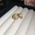 Close-up of champagne crystal and pearl open ring on jewelry display roll - Gold Brown