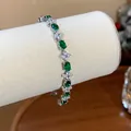 Detailed view of an elegant flower bracelet with green oval and clear round zircons - Silver-Green