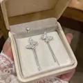 Macro view of sparkling zircon butterfly earrings with elegant silver long tassel detail - Asymmetrical Butterfly Tassel Style (HE33347) / Silver