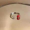 Dettaglio macro di un anello regolabile in argento con ciondolo fragola e stella. - Fragola Stella / Argento