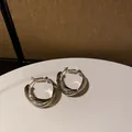 Dettaglio di eleganti orecchini a cerchio in metallo argentato intrecciato stile francese - Perno in Argento Stile Torsione Multistrato Francese (4#) / Argento