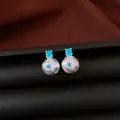 Primo piano di orecchini a perno in argento spazzolato con stelle in zircone blu. - Argento-Blu