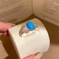 Vintage court style silver ring featuring an oval turquoise stone and textured band - Open Ring / Silver And Blue
