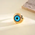 Macro view of a gold evil eye ring with a vibrant blue resin center on a stone base. - Evil Eye Open Ring (HR3613) / Gold-Blue