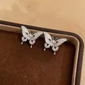 Detailed close-up of exquisite butterfly ear clips with pave-set shimmering cubic zirconia - Butterfly Zircon Style / One Pair / Silver
