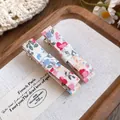 Macro detail showing the floral fabric texture of two sweet bow-shaped duckbill hair clips. - Bowknot Duckbill Clip / Pink Floral