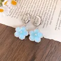 Dettaglio orecchini a fiore in resina azzurra con perle e cerchi a C in argento - Stile ciondolo a fiore / Blu