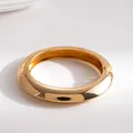 Detailaufnahme eines dicken, goldfarbenen Metallarmreifs mit Scharnierverschluss - Gold Polierter Scharnierarmreif / Gold