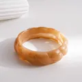 Nahaufnahme eines bernsteinfarbenen Marmor-Harzarmbands mit gewellter, gedrehter Textur - Caramel Amber Marble Texture Resin Bangle / Khaki
