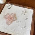 Primer plano de un collar de flores de gasa rosa con detalles de perlas y cuentas de vidrio - Rosa