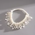Gros plan d'un ras-du-cou en perles de verre blanches avec détails en dentelle tissée - Bracelet-Blanc