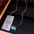 Close-up of light blue beaded necklace with silver and turquoise heart pendants - Blue