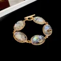 Elegant vintage gold-toned bracelet featuring iridescent oval stones and a toggle clasp. - 78# Bracelet