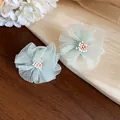 Dettaglio orecchini a fiore in chiffon verde menta con stami di perline delicate - Verde