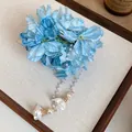 Close-up of blue fabric flower hair clip with elegant long pearl tassel detail - Duckbill Clip - Single Piece / Blue