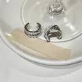 Primer plano de earcuffs plateados con diseño cruzado e incrustación de circonitas - Ear Cuffs Cruzados de Tres Capas (Juego de Dos Piezas) / Plateado