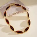 Macro detail of a luxury marquise-cut red gemstone choker necklace in gold finish - Brown