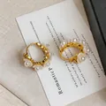 Nahaufnahme von 18 Karat vergoldeten Maiglöckchen-Ohrringen mit eleganten weißen Perlen - Gold Stil (HE33302)