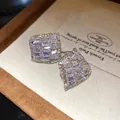 Gros plan de boucles d'oreilles clous carrées évidées serties de zircons étincelants - Style Losange Pavé (HE33272) / Aiguille en argent / Argent
