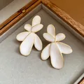 Detailed view of elegant white enamel flower stud earrings with gold edges in a box - Enamel Flower (HE33508) / Gold Edge White