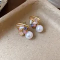 Close-up of geometric 18k gold-plated earrings with colorful crystals and pearls - Pink