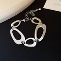 Detailed close-up view of a silver irregular hollow oval link chain bracelet for women - Bracelet / Silver