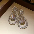 Macro view showing the fine detail of elegant waterdrop earrings with clear crystals - Top Round Bottom Water Drop Style / Silver