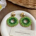 Green glass beaded circular stud earrings with elegant gold finish - Green